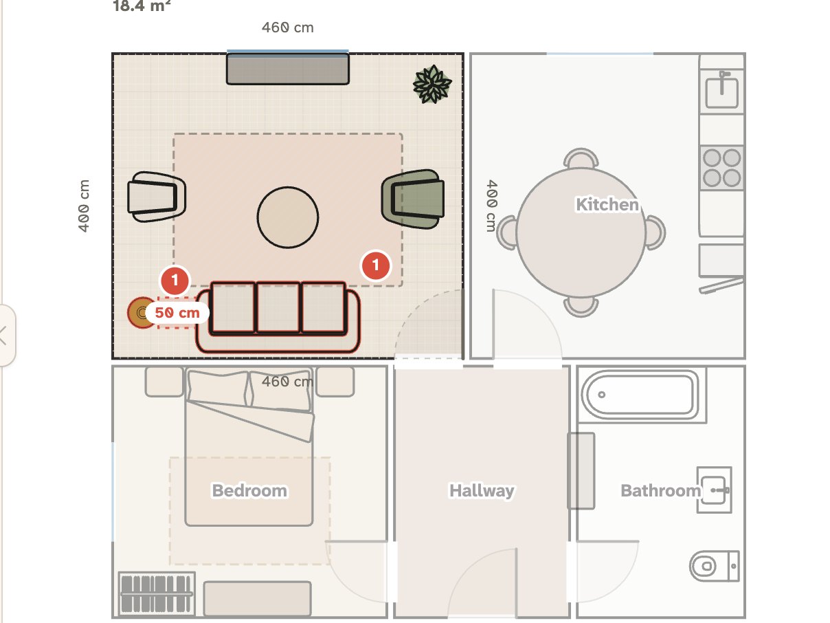 A Nooked floor plan of an apartment with a sofa, two armchairs and a round coffee table on a rug in the living room